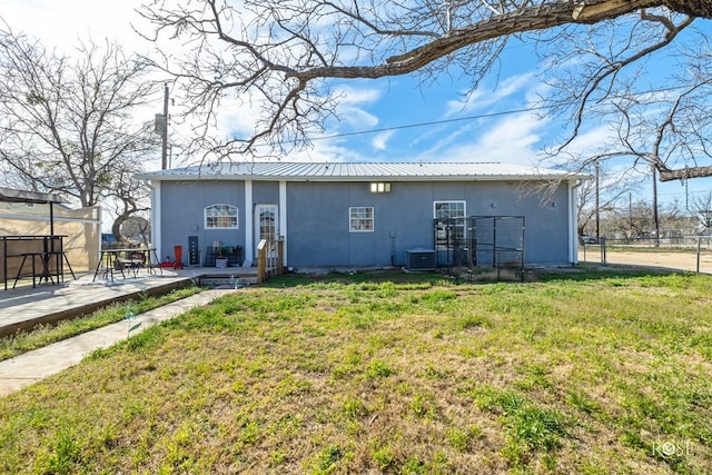 rear view of house with a lawn, a patio, and central air condition unit