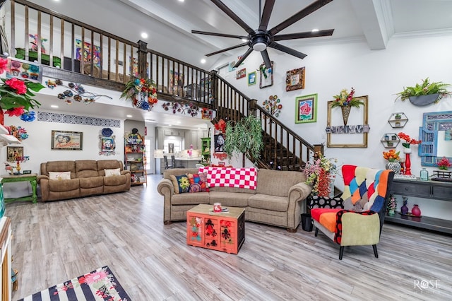 living room featuring crown molding, ceiling fan, beam ceiling, and light hardwood / wood-style flooring