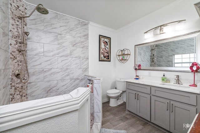 bathroom with vanity, crown molding, toilet, and a tile shower