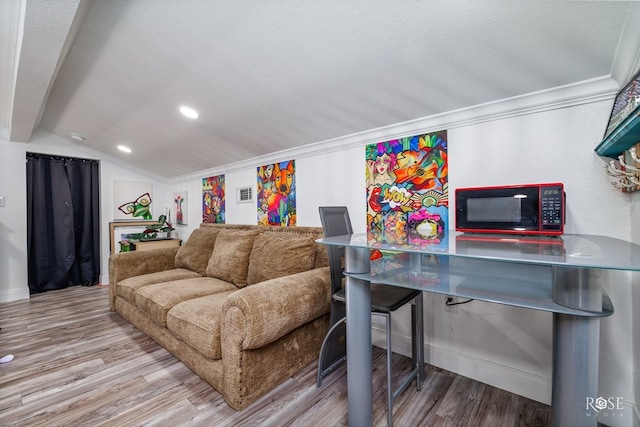 living room featuring lofted ceiling and light hardwood / wood-style flooring