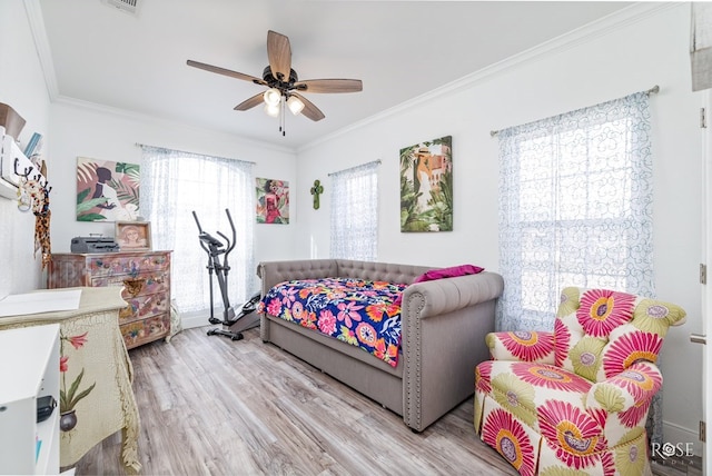 bedroom featuring hardwood / wood-style floors, ornamental molding, and ceiling fan