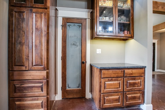 2030 Silver Creek Ct, San Angelo, TX 76904 - kitchen featuring glass insert cabinets, baseboards, and dark countertops