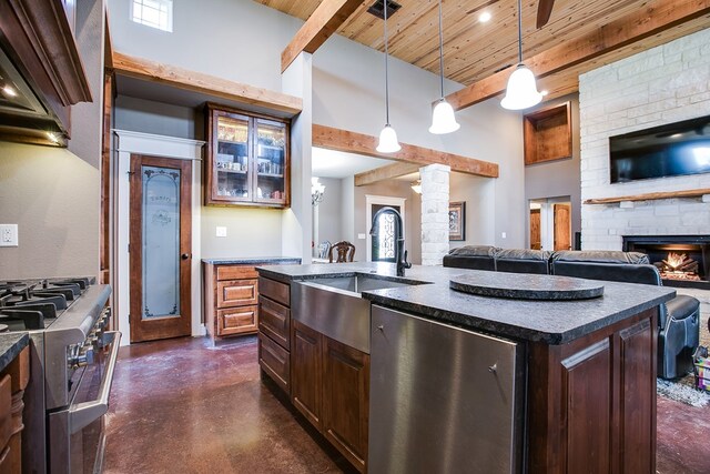 2030 Silver Creek Ct, San Angelo, TX 76904 - kitchen featuring appliances with stainless steel finishes, a sink, dark countertops, concrete flooring, and a brick fireplace