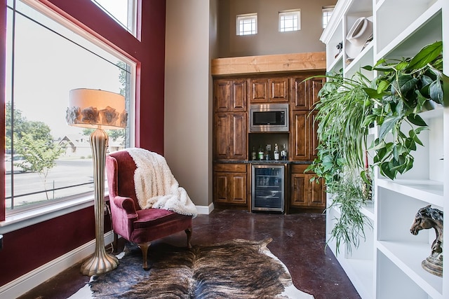 2030 Silver Creek Ct, San Angelo, TX 76904 - indoor dry bar with wine cooler, stainless steel microwave, concrete floors, baseboards, and a high ceiling
