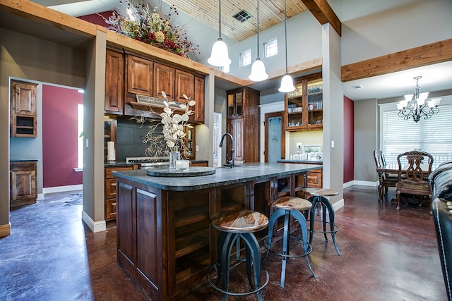 2030 Silver Creek Ct, San Angelo, TX 76904 - kitchen with concrete floors, baseboards, a center island with sink, a kitchen breakfast bar, and high vaulted ceiling