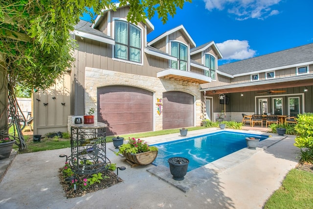 2030 Silver Creek Ct, San Angelo, TX 76904 - rear view of house with stone siding, a garage, board and batten siding, a ceiling fan, and a patio