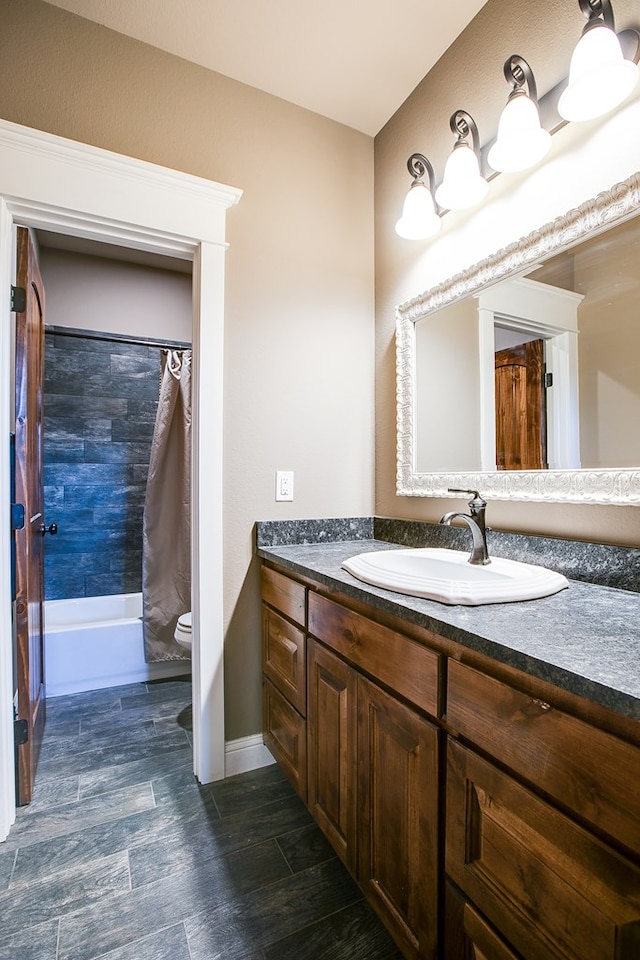 2030 Silver Creek Ct, San Angelo, TX 76904 - full bath featuring toilet, vanity, shower / bathtub combination with curtain, baseboards, and wood finished floors