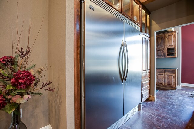 2030 Silver Creek Ct, San Angelo, TX 76904 - kitchen with stainless steel built in refrigerator, baseboards, glass insert cabinets, and finished concrete flooring