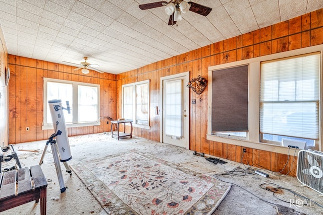 miscellaneous room featuring wooden walls and ceiling fan