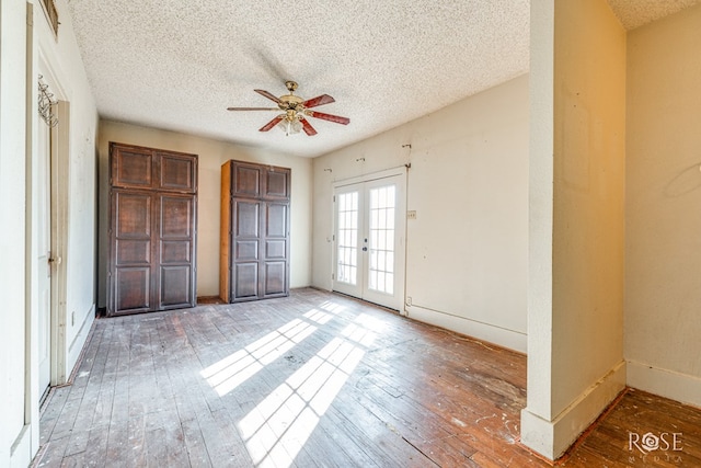 unfurnished bedroom featuring hardwood / wood-style flooring, access to exterior, ceiling fan, a textured ceiling, and french doors