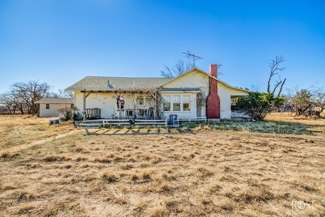 rear view of property featuring a yard