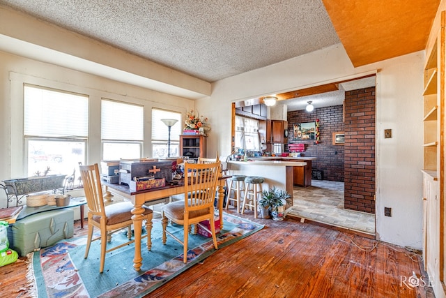 dining space with wood-type flooring and a textured ceiling