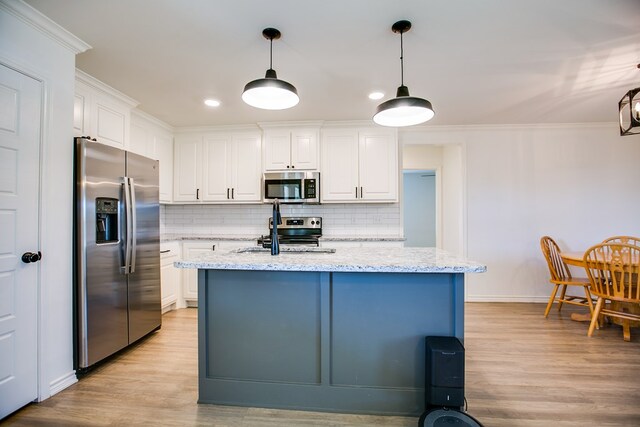 909 E 39th St, San Angelo, TX 76903 - kitchen featuring appliances with stainless steel finishes, light wood-style flooring, white cabinets, and ornamental molding