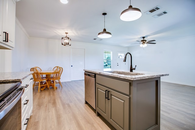 909 E 39th St, San Angelo, TX 76903 - kitchen featuring stainless steel appliances, gray cabinetry, light wood-style floors, a center island with sink, and ornamental molding