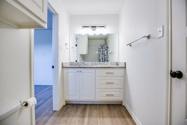 909 E 39th St, San Angelo, TX 76903 - bathroom with wood finished floors, vanity, a shower with shower curtain, and backsplash