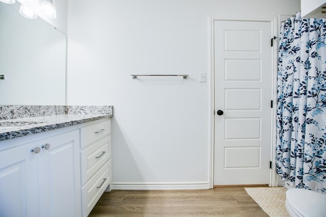 909 E 39th St, San Angelo, TX 76903 - bathroom with vanity, wood finished floors, and a shower with curtain