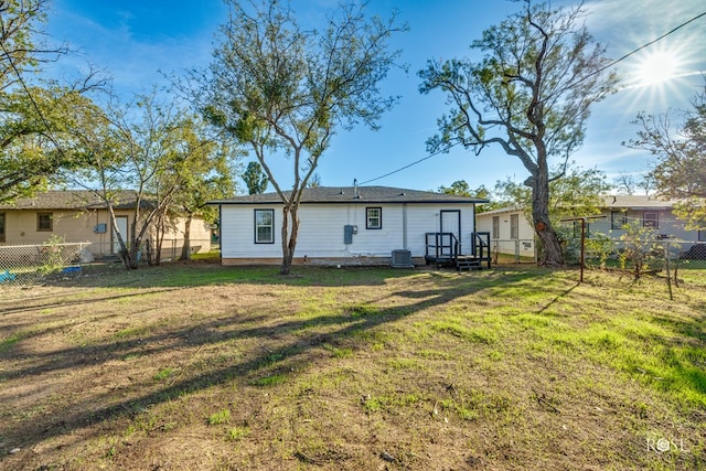 rear view of house with a lawn and central air condition unit