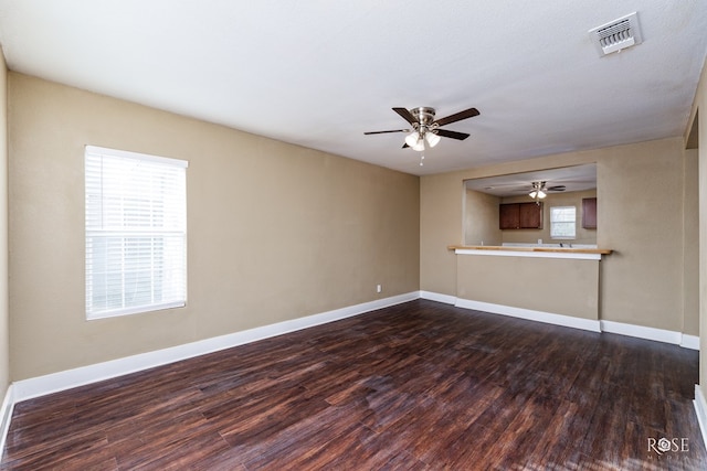 unfurnished living room with dark hardwood / wood-style floors and ceiling fan