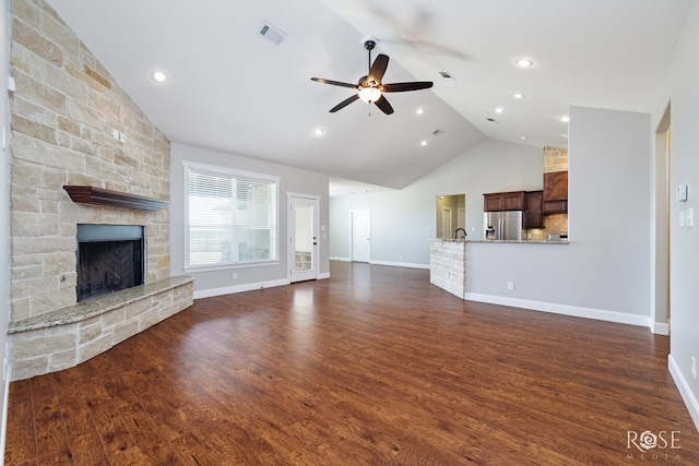 unfurnished living room with visible vents, high vaulted ceiling, a ceiling fan, dark wood-style floors, and a stone fireplace