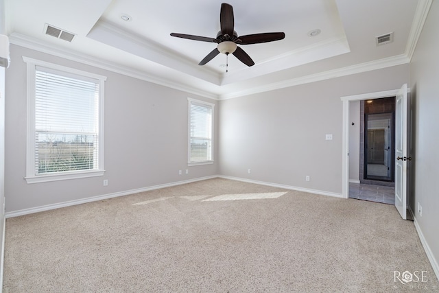 unfurnished room featuring light carpet, visible vents, a raised ceiling, and ornamental molding