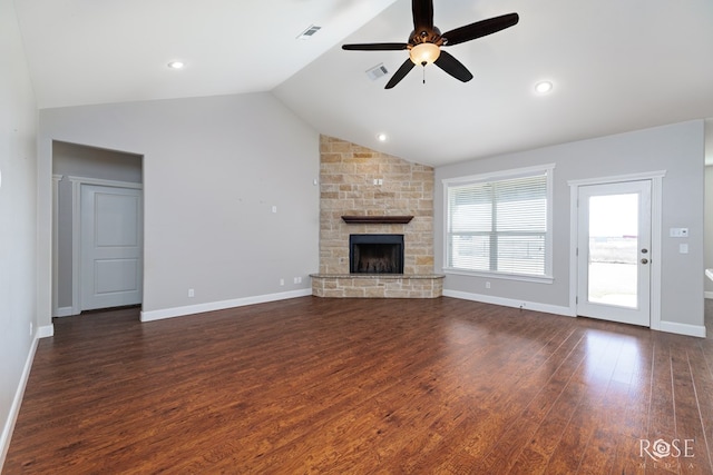 unfurnished living room with a stone fireplace, lofted ceiling, visible vents, and dark wood-style flooring