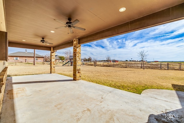 view of patio with a playground, a ceiling fan, and a fenced backyard