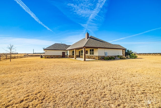 back of property featuring stucco siding, fence, a chimney, and a patio area