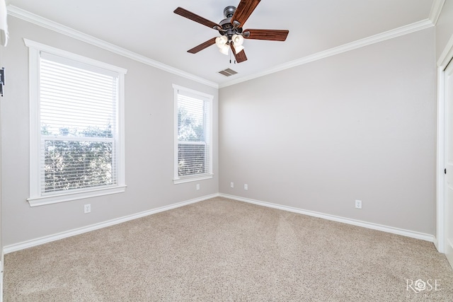 carpeted spare room featuring crown molding, baseboards, visible vents, and ceiling fan