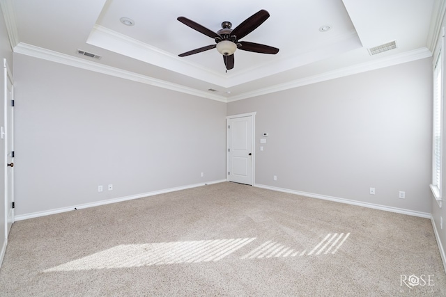 carpeted spare room with visible vents, crown molding, and a tray ceiling