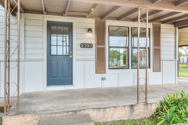 entrance to property featuring board and batten siding and covered porch