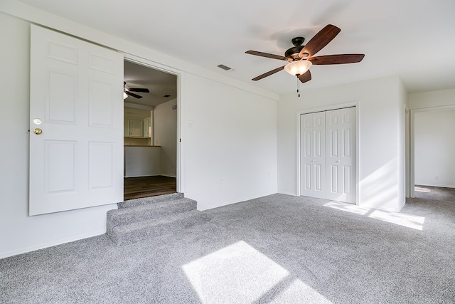 unfurnished bedroom with carpet, visible vents, a closet, baseboards, and ceiling fan