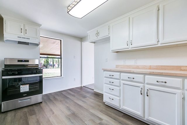 kitchen featuring white cabinets, stainless steel range with gas cooktop, wood finished floors, light countertops, and under cabinet range hood