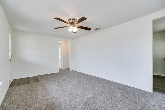 unfurnished room featuring carpet floors, visible vents, baseboards, and ceiling fan