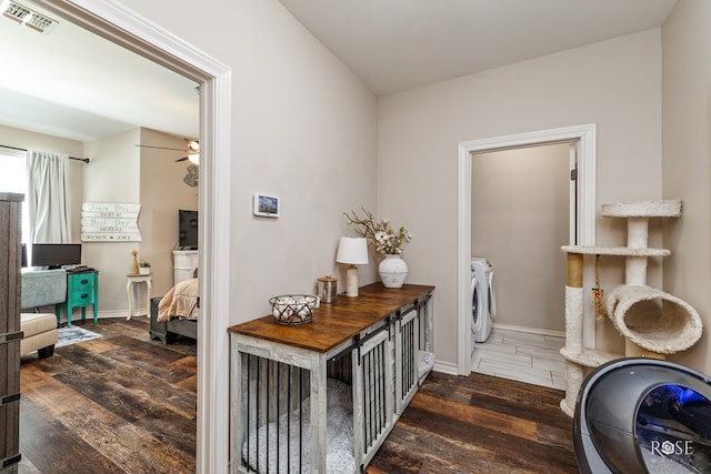 interior space with visible vents, washer and dryer, dark wood-type flooring, and baseboards