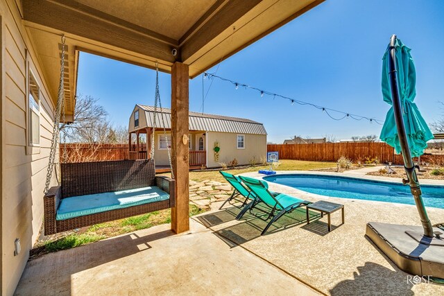 view of pool with a fenced in pool, a patio, an outbuilding, and a fenced backyard