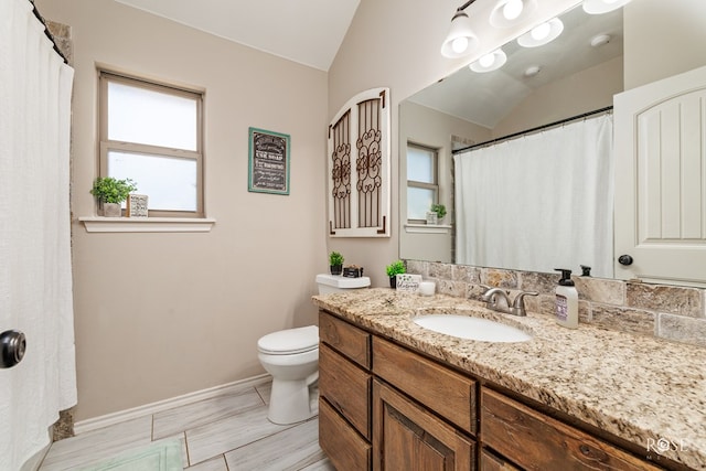 bathroom with toilet, lofted ceiling, a shower with curtain, baseboards, and vanity