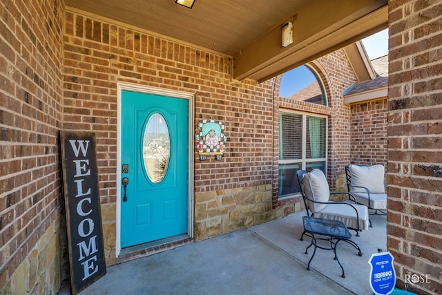 property entrance featuring brick siding and roof with shingles