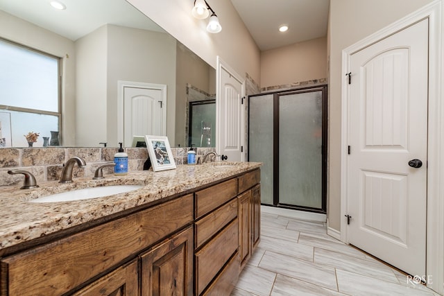 bathroom featuring a sink, double vanity, and a shower stall