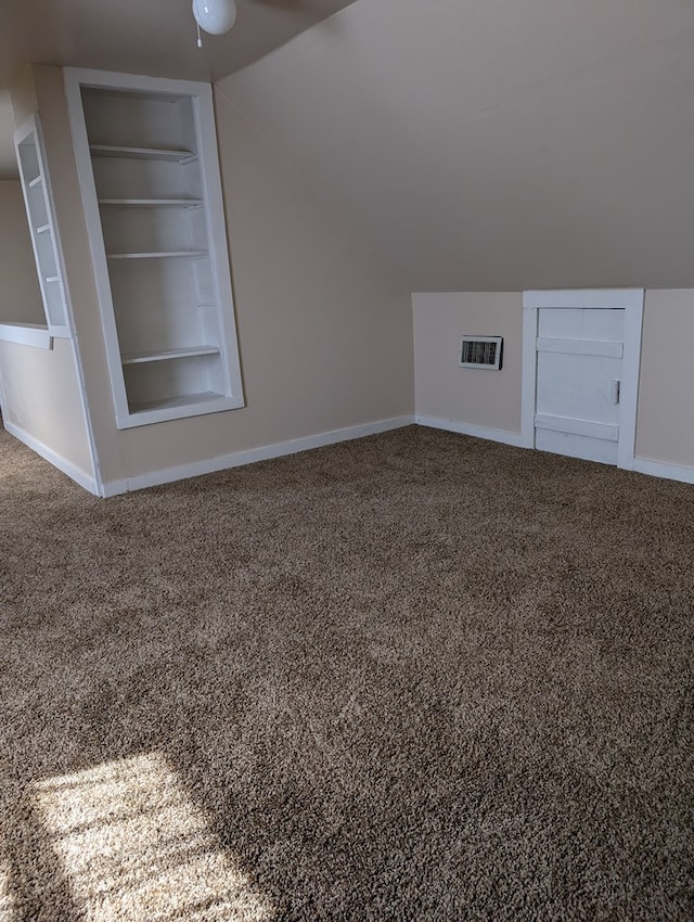 718 N Adams Ave, San Angelo, TX 76901 - additional living space with built in shelves, carpet floors, lofted ceiling, baseboards, and a ceiling fan