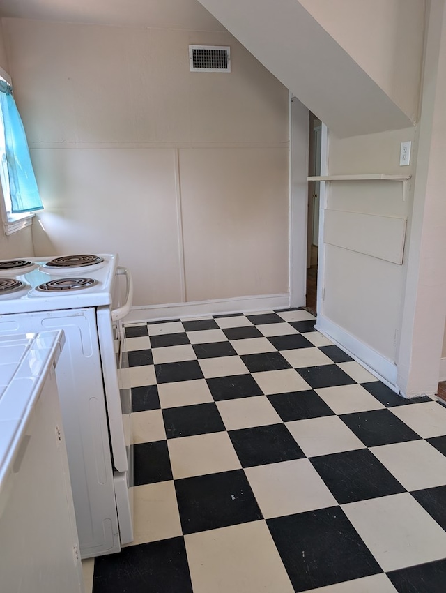 kitchen featuring range with electric stovetop, visible vents, light floors, tile counters, and a decorative wall