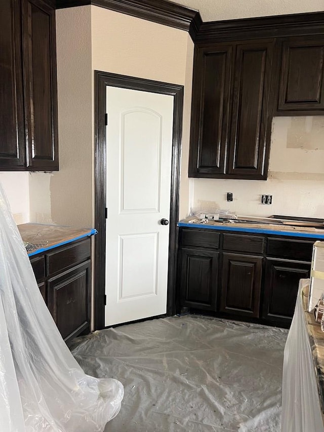 kitchen with crown molding and dark brown cabinetry