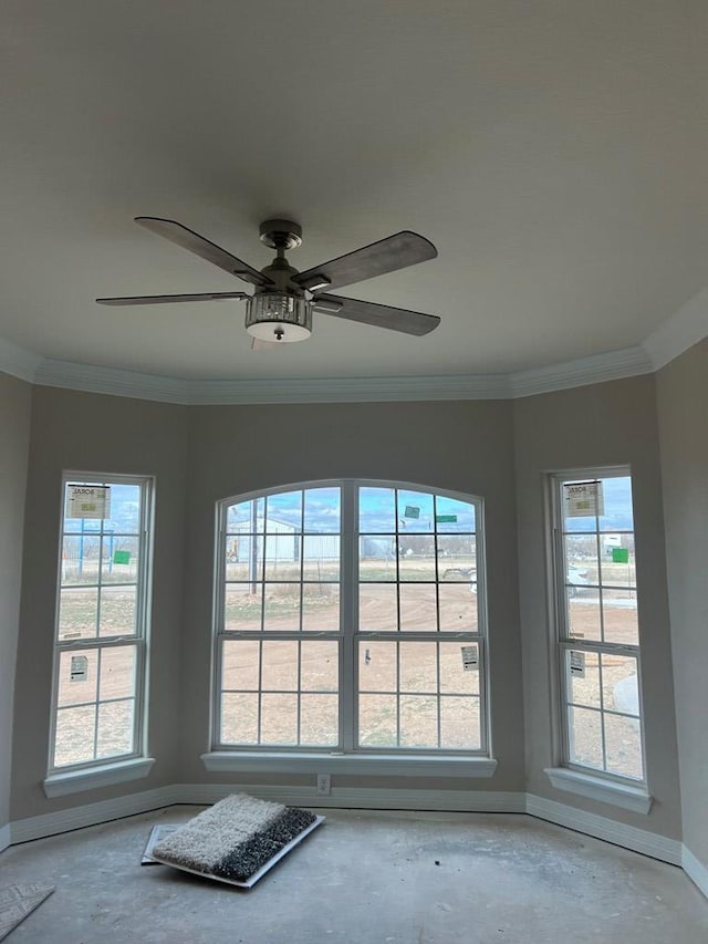 spare room with ornamental molding and ceiling fan