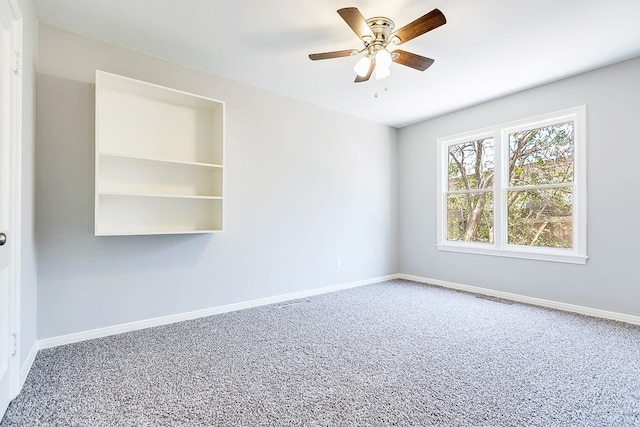 carpeted empty room with visible vents, baseboards, and a ceiling fan