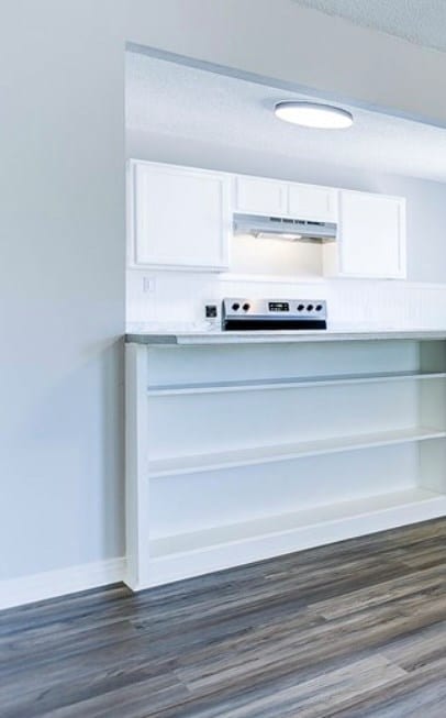 kitchen featuring white cabinets, electric range oven, light countertops, a textured ceiling, and open shelves