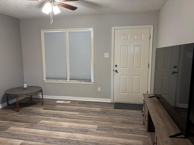 entryway featuring visible vents, dark wood finished floors, a textured ceiling, and baseboards