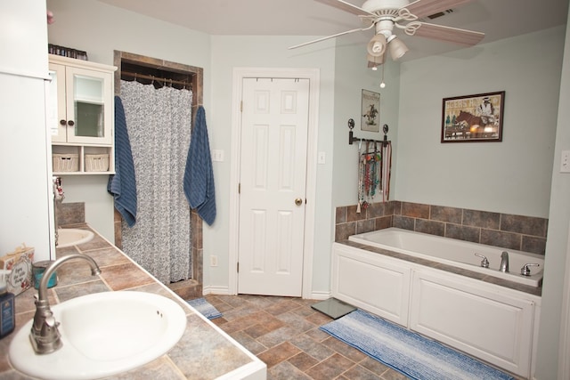 10581 Ballard Rd, San Angelo, TX 76901 - full bath with ceiling fan, stone finish flooring, a garden tub, and curtained shower