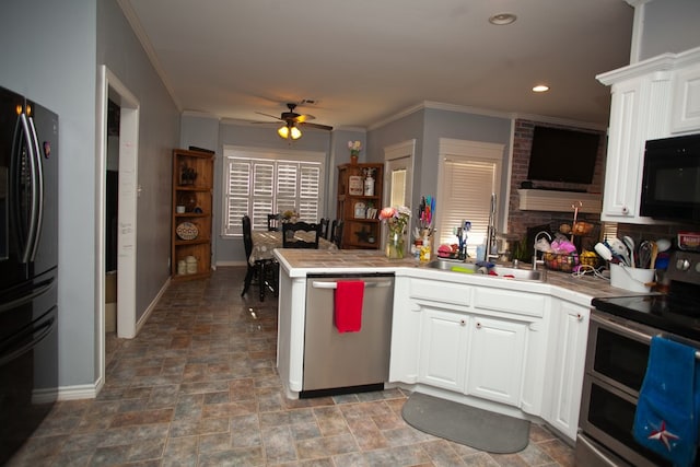 10581 Ballard Rd, San Angelo, TX 76901 - kitchen featuring black appliances, tile counters, stone finish flooring, ceiling fan, and crown molding