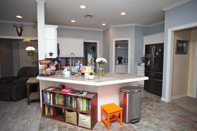 10581 Ballard Rd, San Angelo, TX 76901 - kitchen with black fridge with ice dispenser, a peninsula, tile countertops, white cabinets, and recessed lighting