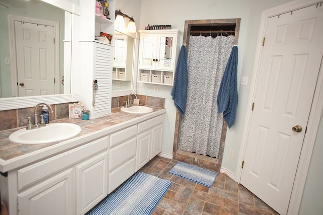 10581 Ballard Rd, San Angelo, TX 76901 - full bathroom featuring a shower stall, baseboards, double vanity, and stone finish flooring