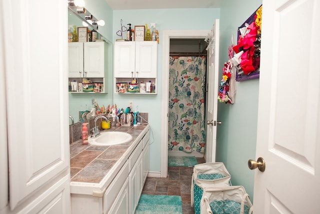 10581 Ballard Rd, San Angelo, TX 76901 - bathroom with stone finish flooring, vanity, and a shower with shower curtain